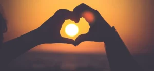 silhouette of person's hands forming heart