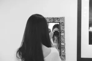 persona tomando una foto de su reflejo en el espejo. Qué es ser narcisista