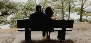 pareja sentada en un parque. Migrar en pareja