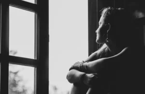 mujer viendo por una ventana. fomo