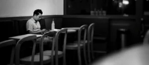 hombre solo sentado en una cafetería. Soledad del Emigrante